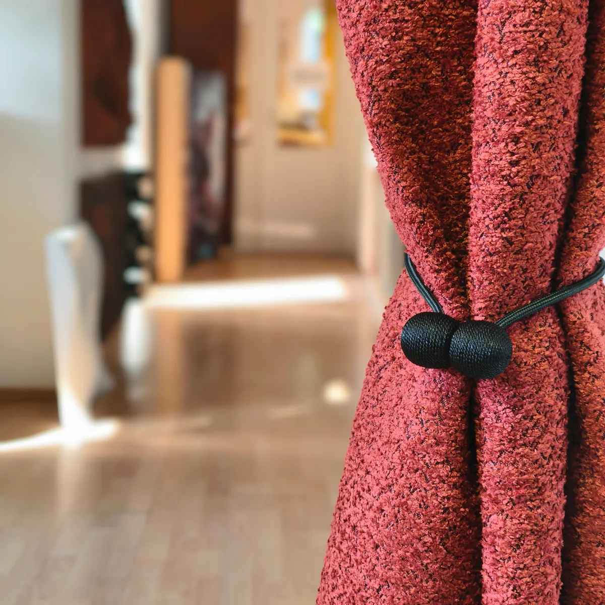 Rød bouclé rumdelergardin samlet med dekorativ opbinding